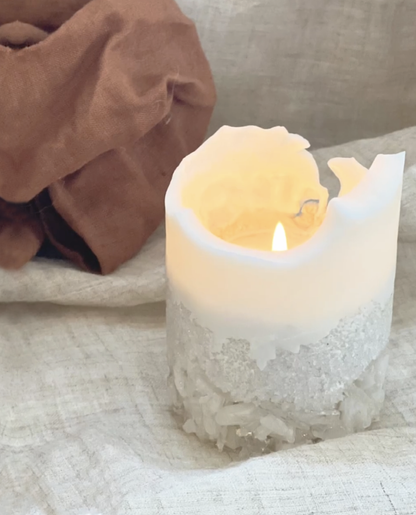 White Crystal Candle Lit and Burning Showing the Beautiful Shape the Candle Takes When the Wax Starts to Melt