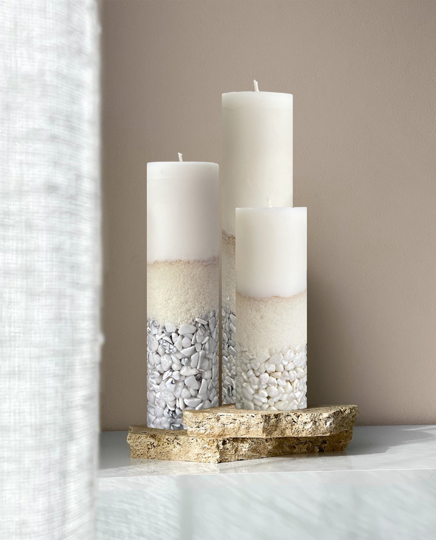 Three Different Size Candles of Howlite Crystals Displayed on a Travertine Slabs Showing How To Insert This Decorative Item to Brings a Statment and Bold Look to Home Decor.